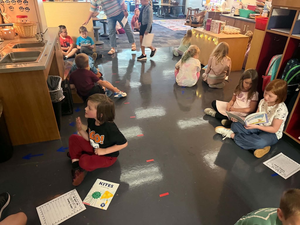 many groups of two sitting together and reading to each other