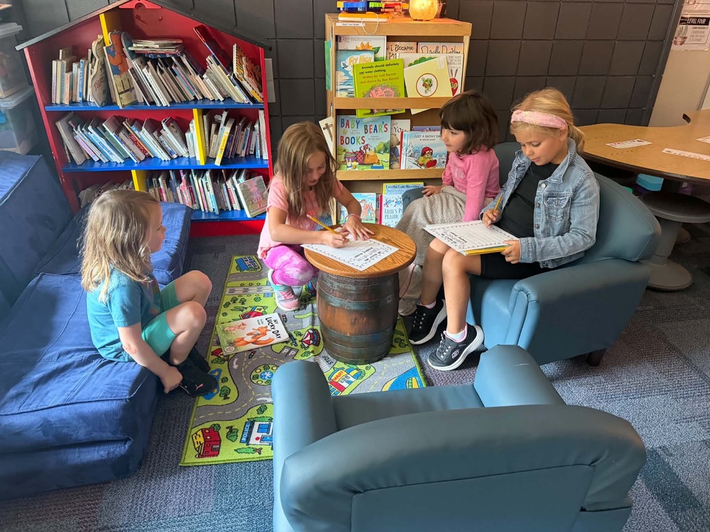 4 female studnets , two filling out pieces of paper the other two watching