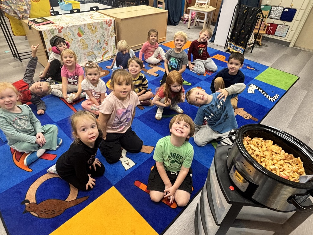 preschoolers sitting on a rug waiting for applesauce