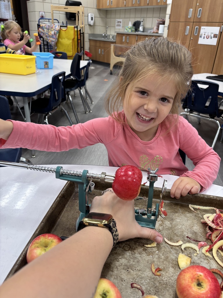 female preschooler peeling an apple