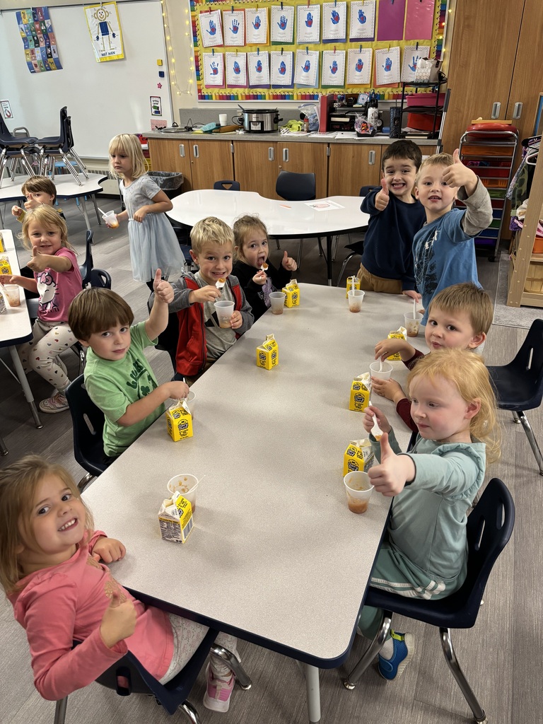 preschoolers at their table giving thumbs up