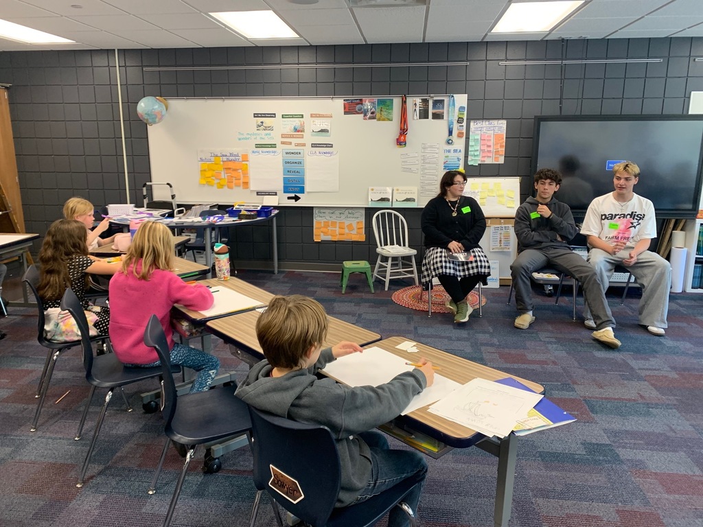 three HS students sitting in front of students at CRES teaching them about emotions