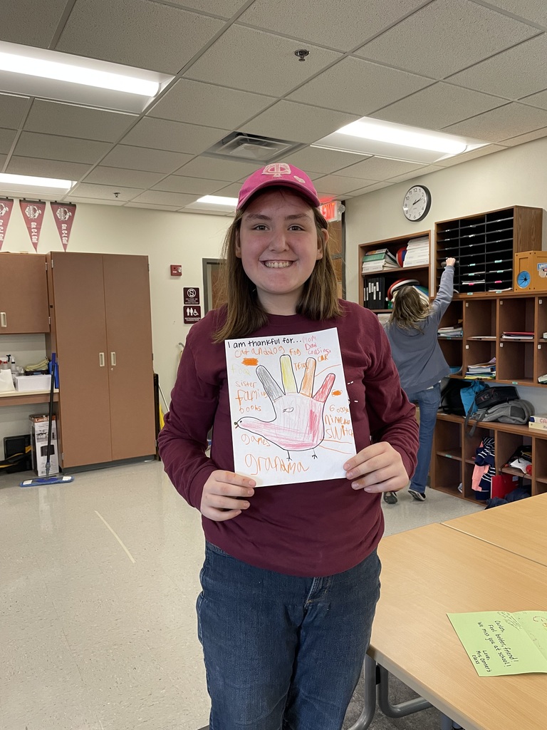 student holding a hand turkey with words on the paper