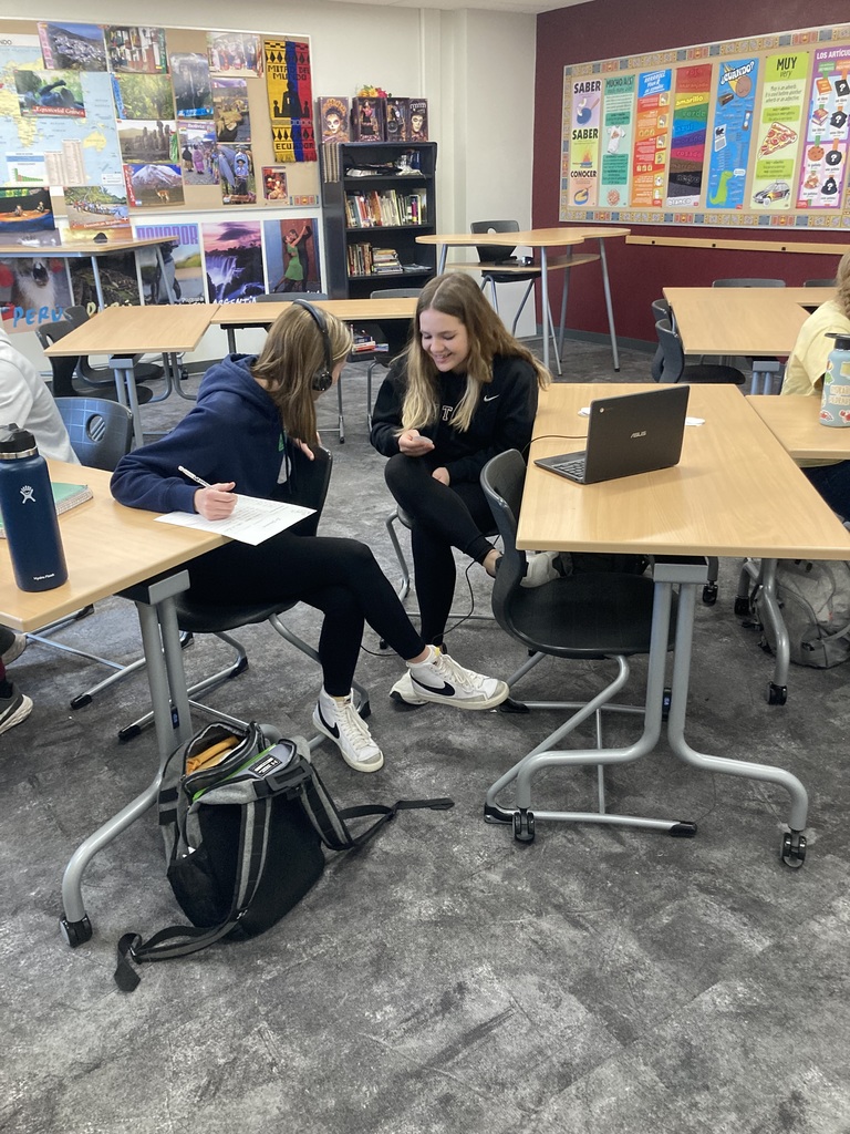 two females at tables one with headphones