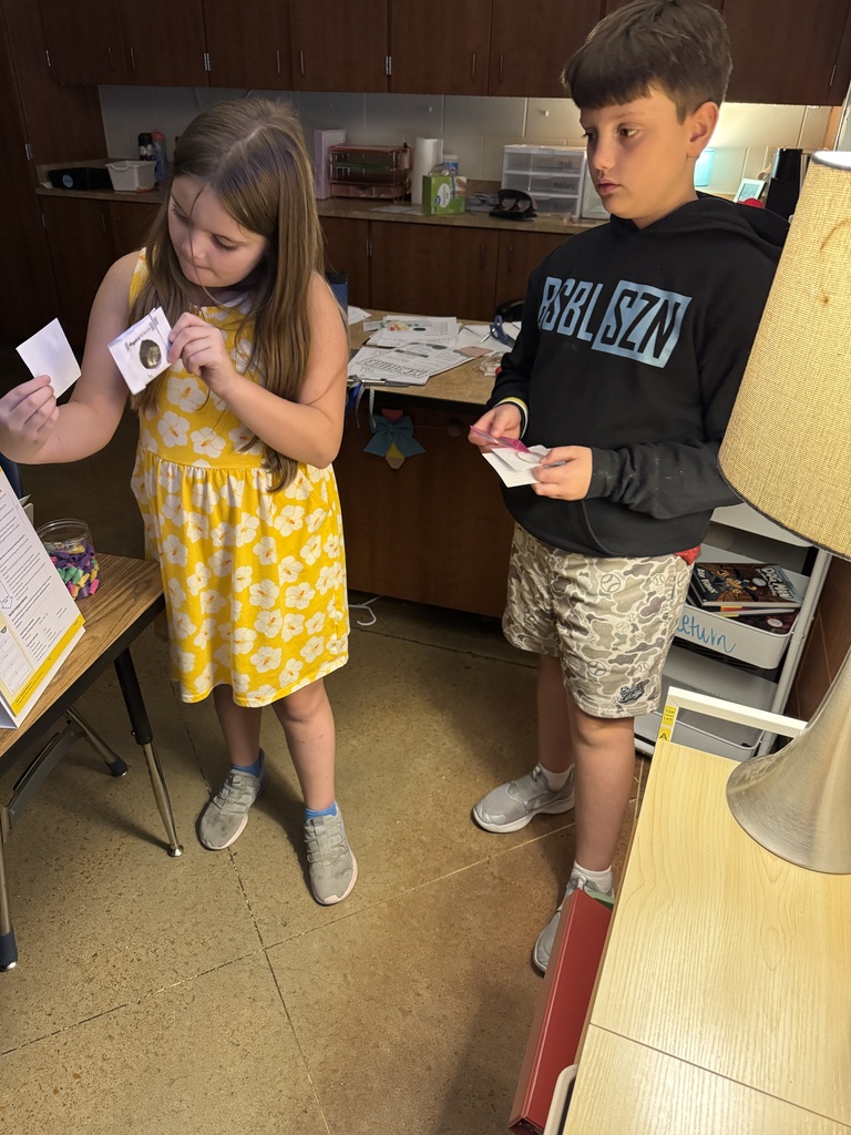 Students using lamp for eye experiment. 