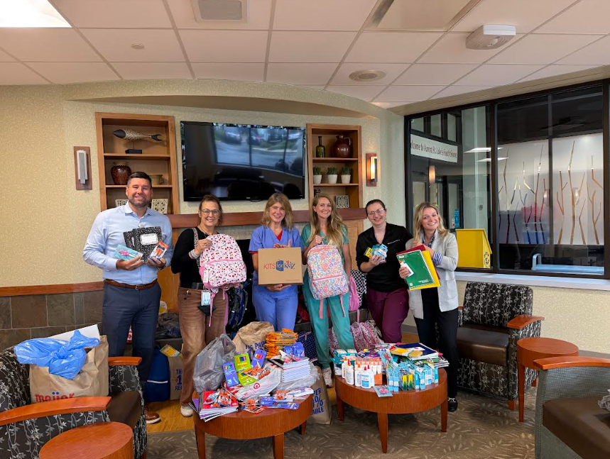 staff holding school supplies