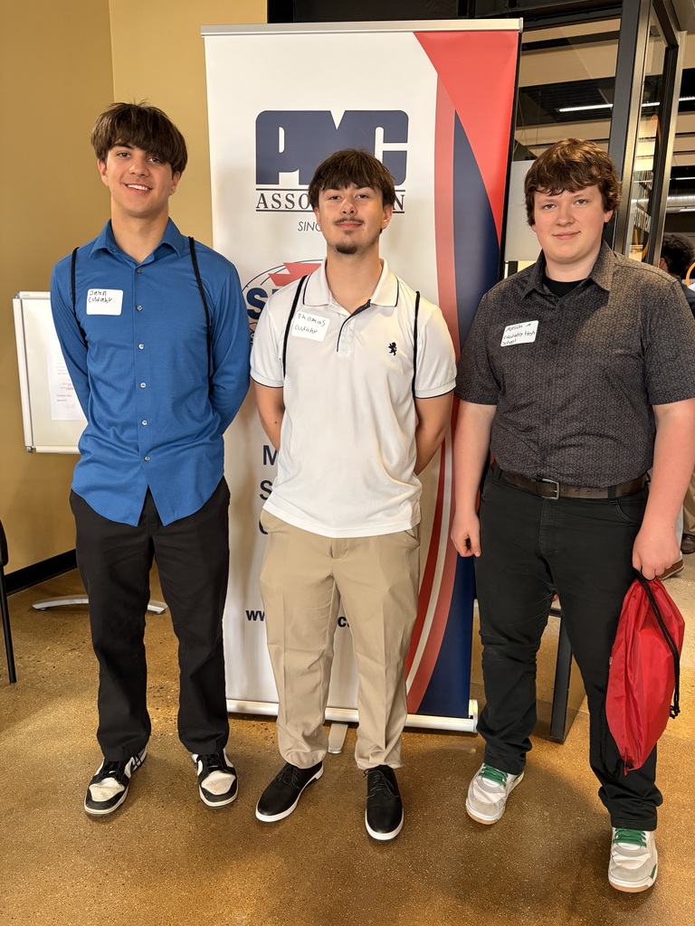 picture of three high school students in front of a banner