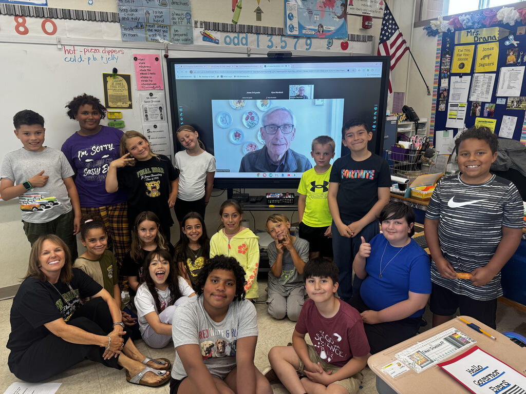 Group of students with a screen showing zoom call with mayor