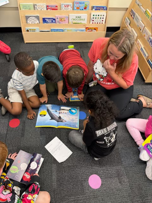 student and teacher reading on carpet