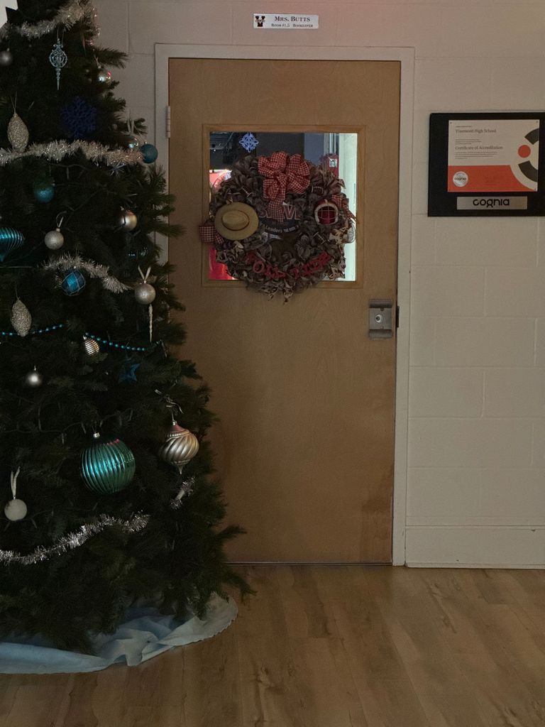 Christmas tree in corner and office door decorated with a Christmas wreath