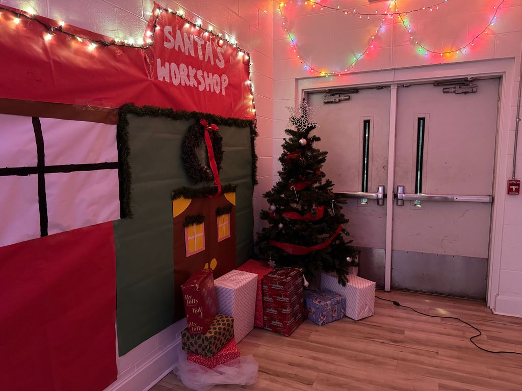 Hall decorated like Santa's workshop with a real Christmas tree and wrapped boxes in the corner