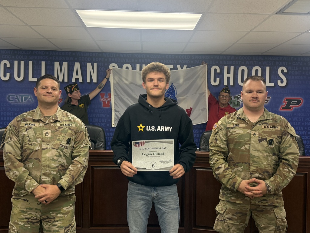 Three men in military uniforms, one holding a certificate, stand before a backdrop with "Cullman County Schools" and a flag.