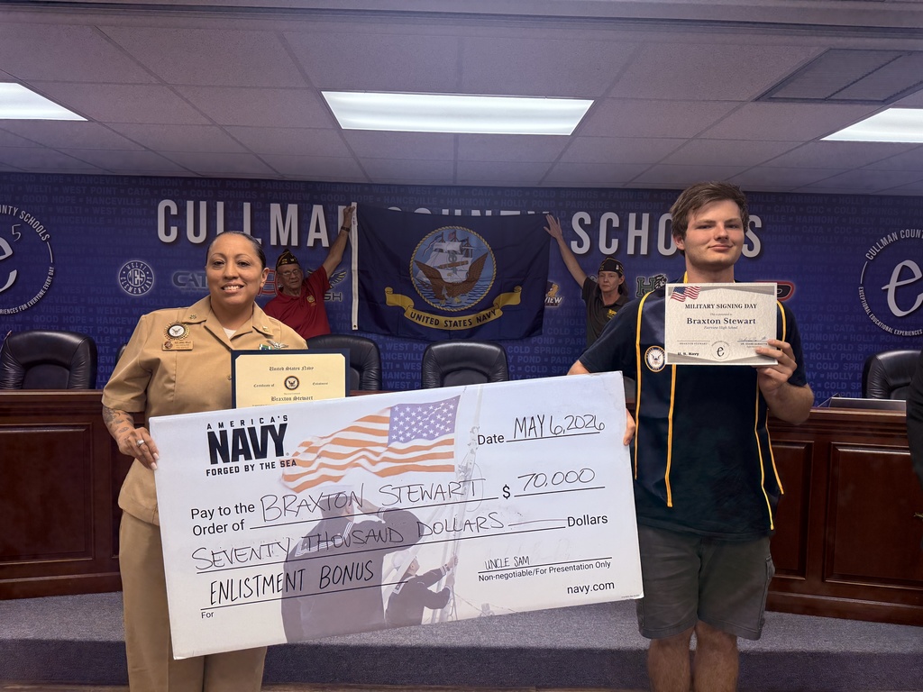 Two people hold large checks, one person in a military uniform and one in a t-shirt.