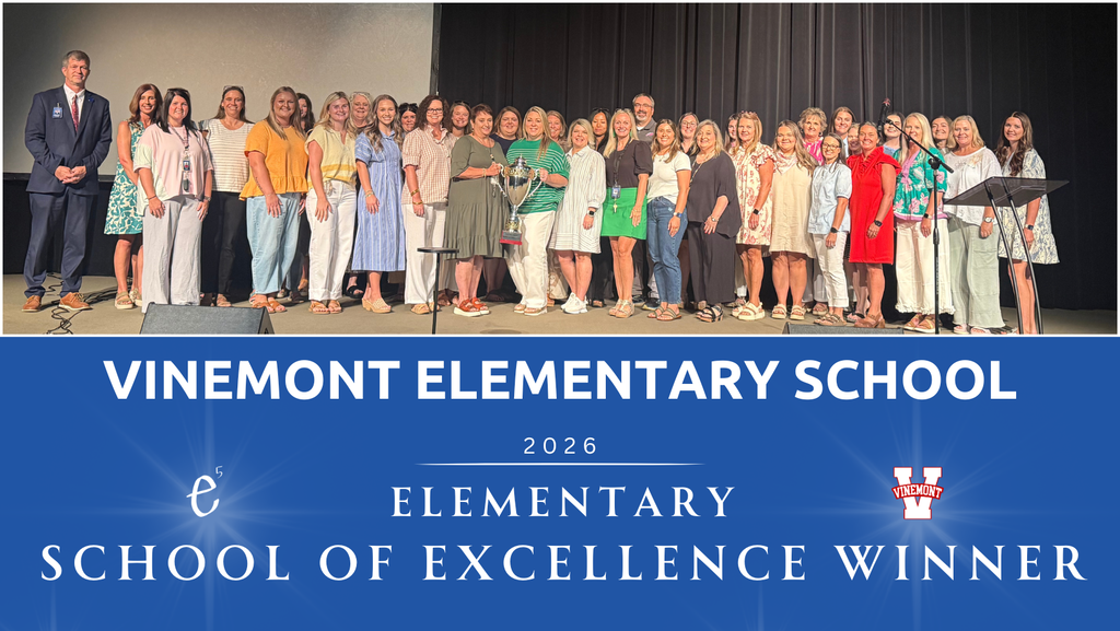 A group of people wearing various colors stand in a row on a stage. A banner reads "Vinemont Elementary School 2026".