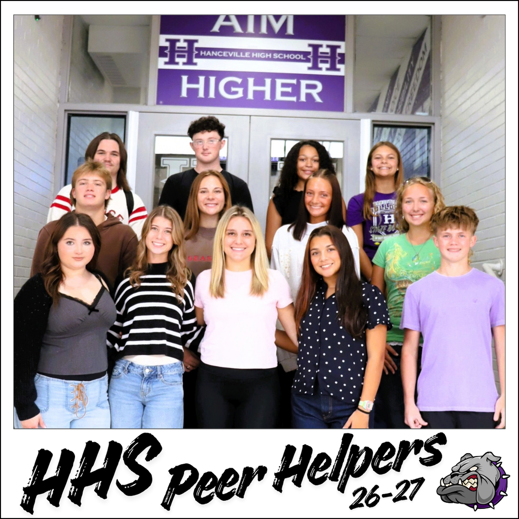 A group of students stands in front of a building with a sign reading "Aim Higher." Text overlay reads "HHS Peer Helpers 26-27."
