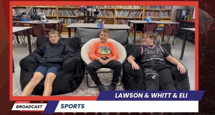 Three students in bean bags, one wearing an orange shirt, another in black, and one in blue shorts.