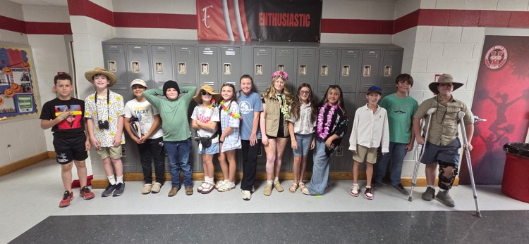 Group of students in hats and sneakers posing for a photo in a locker room.