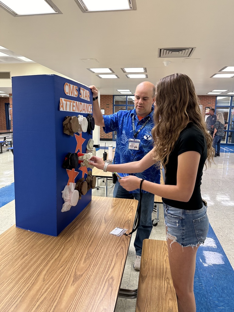 Students picking a prize for winning the perfect attendance award.