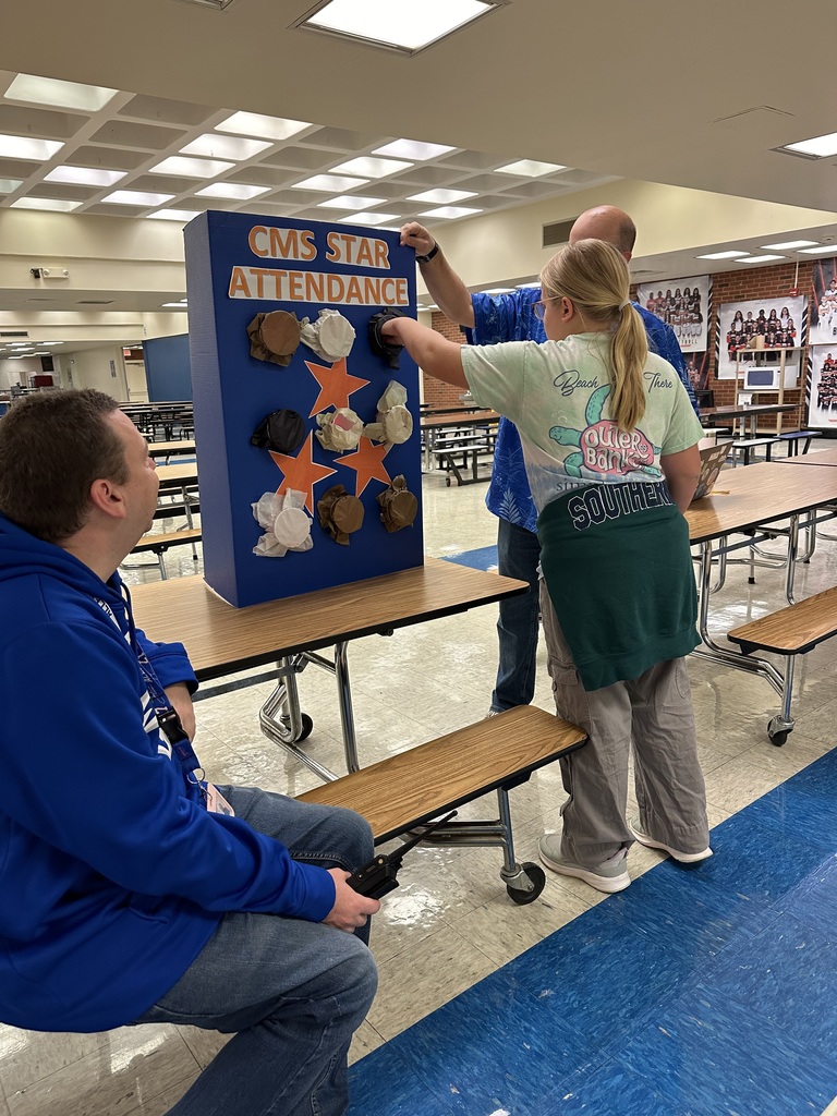 Students picking a prize for winning the perfect attendance award.