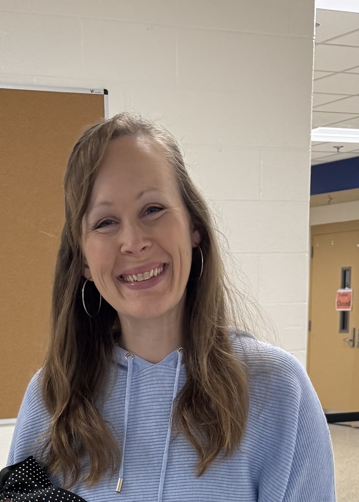 Photograph of a smiling woman in a hallway