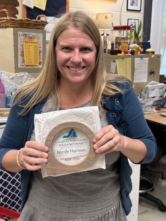 Mrs. Nicole Harmon smiling and holding her 2024–2025 Culpeper County Public Schools Inclusive Spirit Award plaque in a classroom setting.
