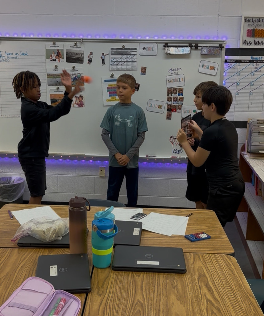 Four students playing basketball in math class