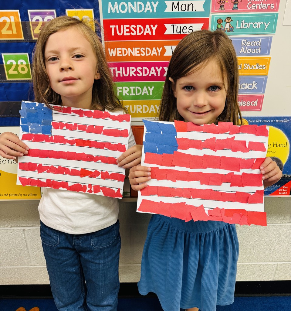 Two young students holding up American flag art