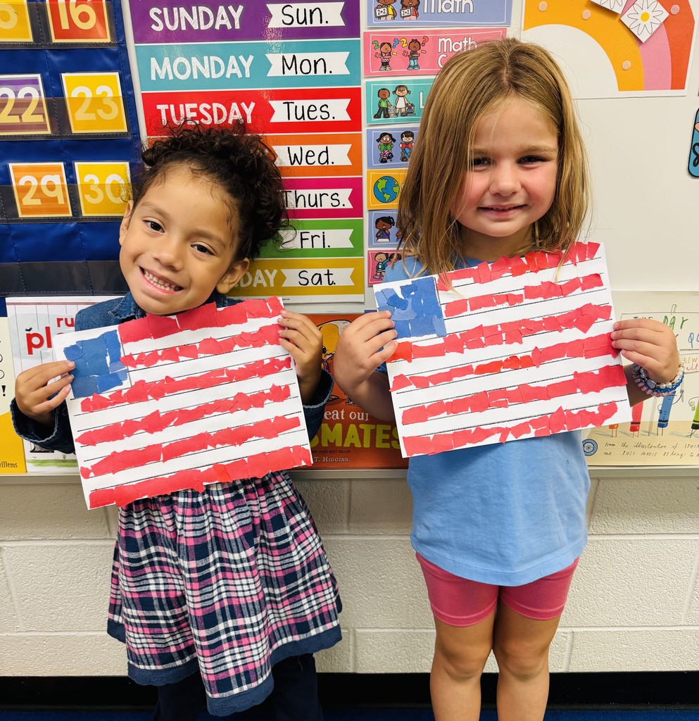 Two young students holding up American flag art