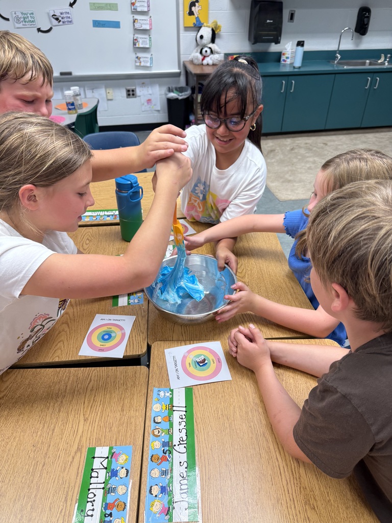 Students reaching towards a bowl of slime and mixing it together