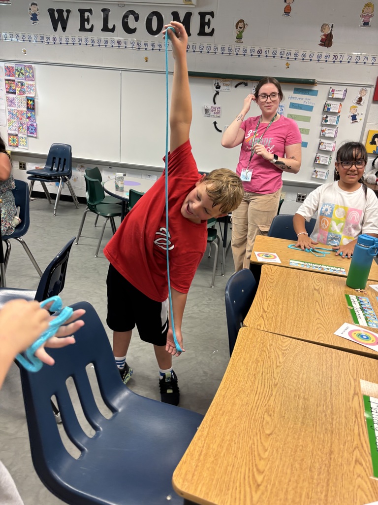 Boy stretching slime out very long with a staff member looking from behind