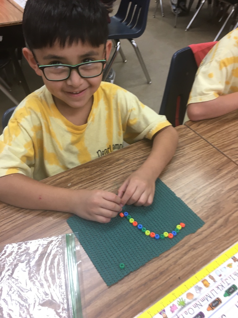 student in yellow tie dye shirt and colorful beads