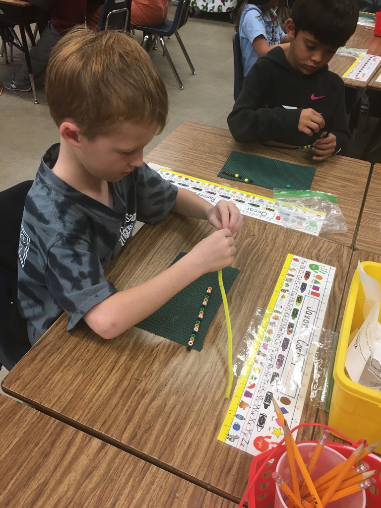 student in black and gray shirt with colorful beads