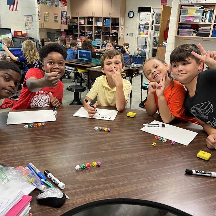Mrs McFarlands class poses for pictures while playing a place value game