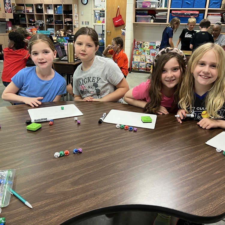Mrs McFarlands class poses for pictures while playing a place value game