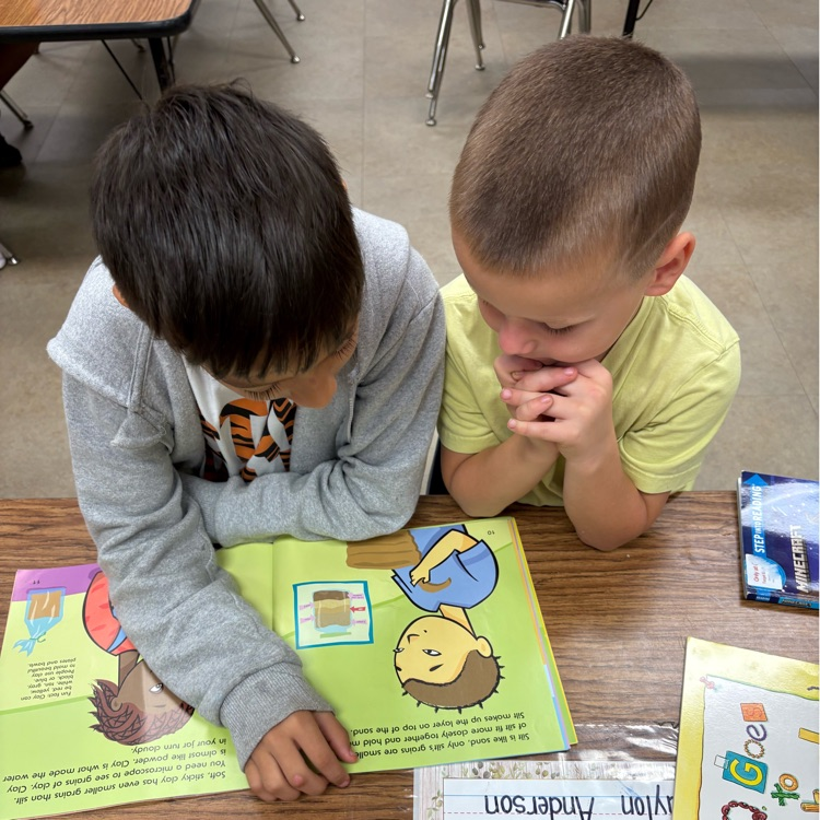 two boys reading a book together