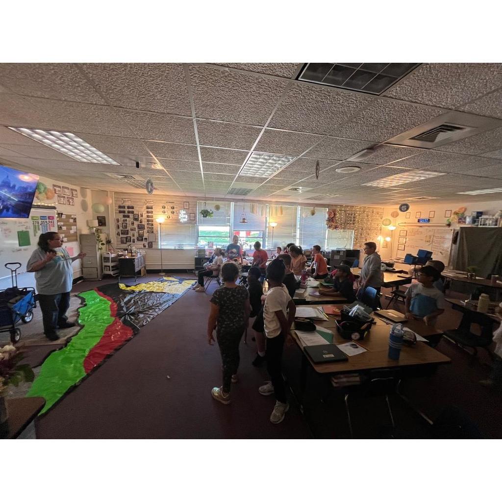 Students stand and participate while Mrs. DeNicola continues the soil and water conservation lesson with the floor map.
