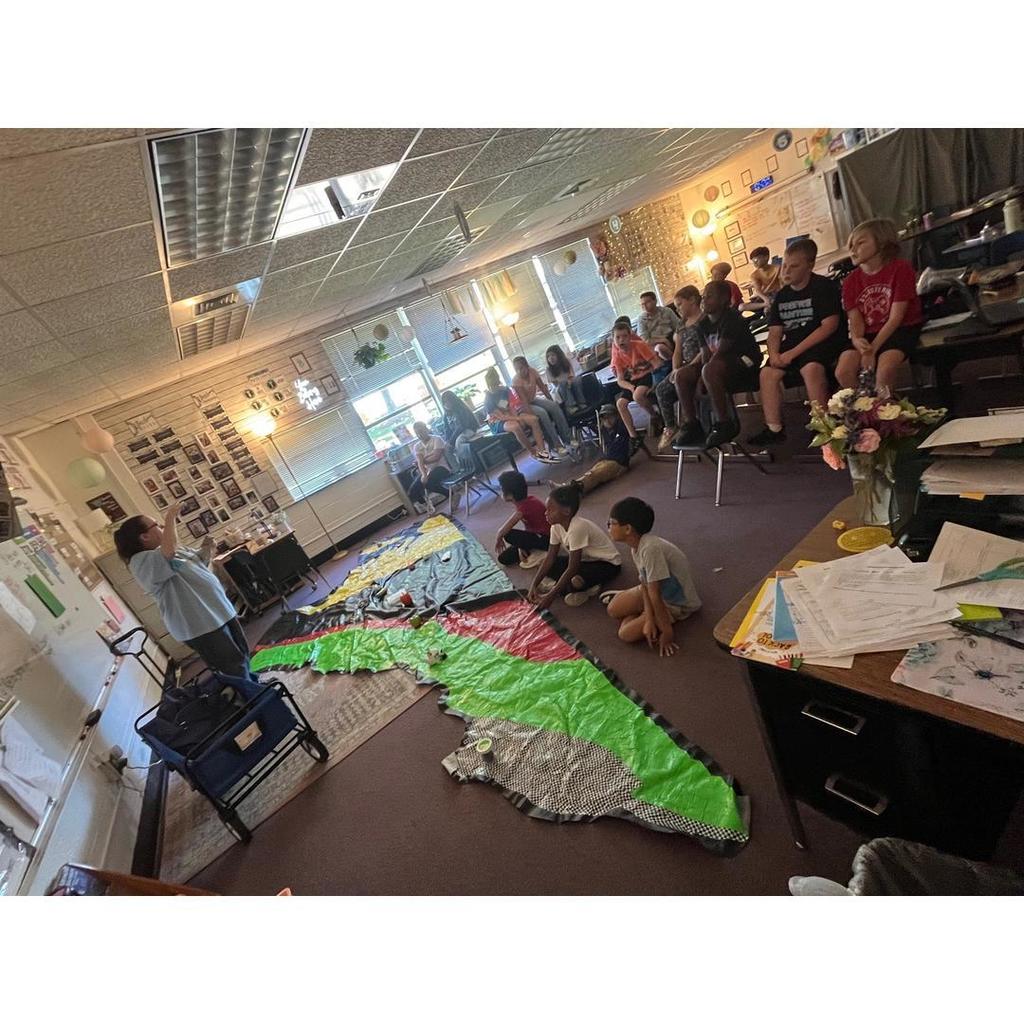 Mrs. DeNicola stands at the front of the classroom, teaching while students watch the Virginia regions map activity.