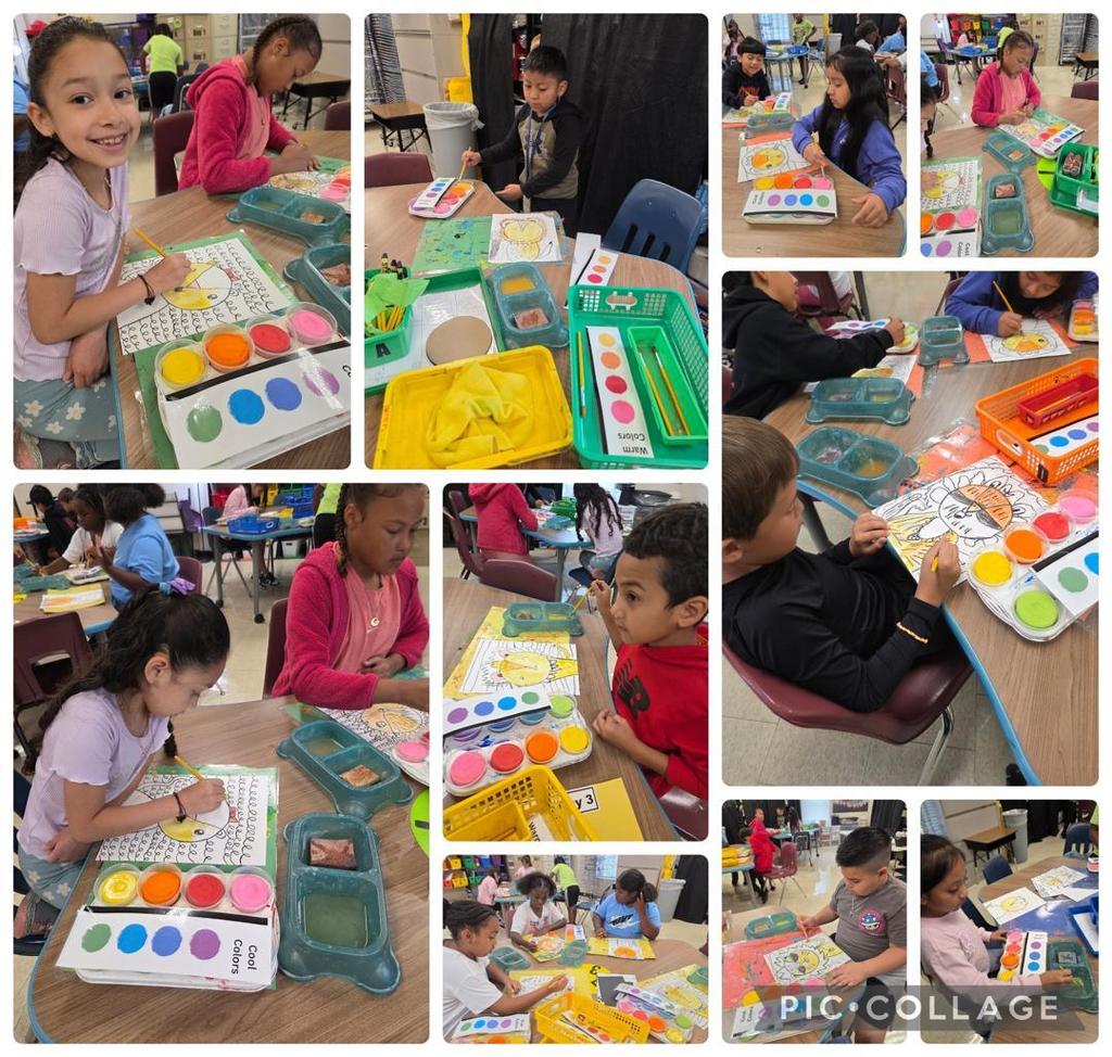 Students painting their lion drawings with bright watercolors at tables, with trays of paints and brushes spread out