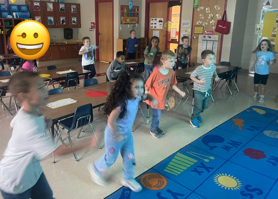 a group of students are practicing glow yoga spread around the classroom during indoor recess