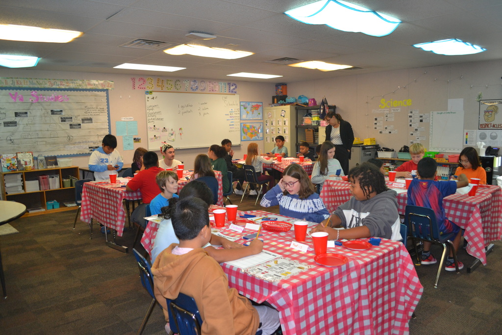Students sitting at their desk in a classroom that is decorated like a diner.