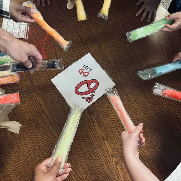 Student in a circle holding popsicles.