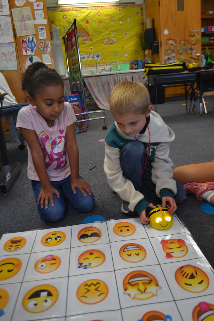 Two students work on their classroom floor using a Beebot.