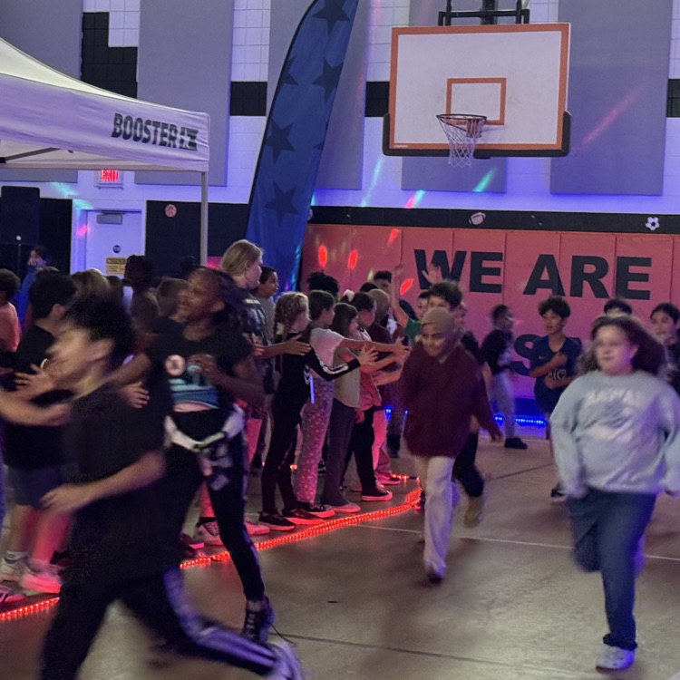 Students running during the glow run in the gym