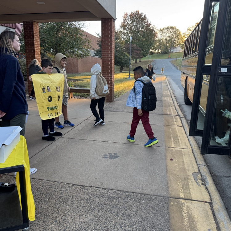 students standing outside holding signs 