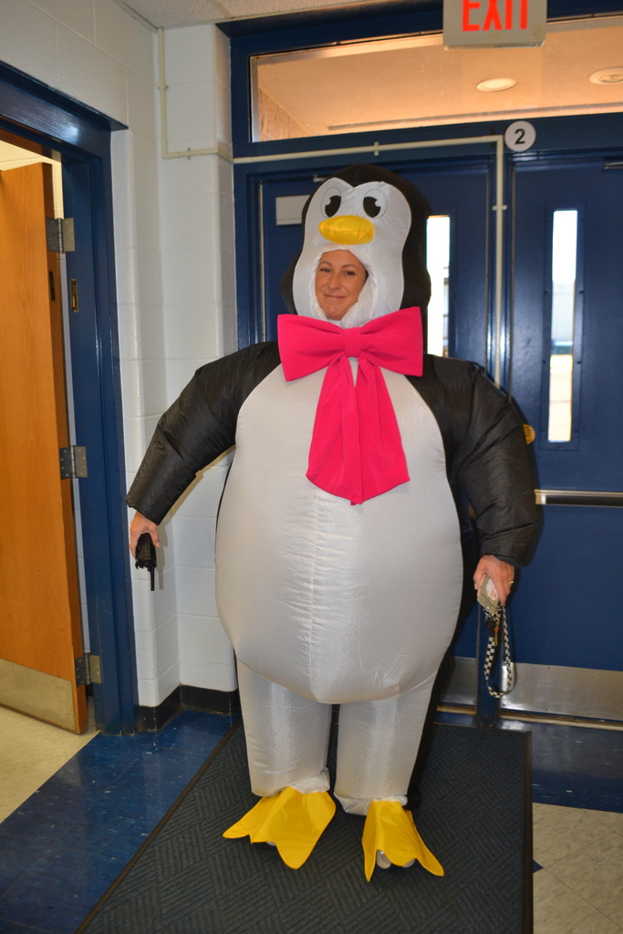 Inflatable penguin costume on a smiling adult in a school hallway