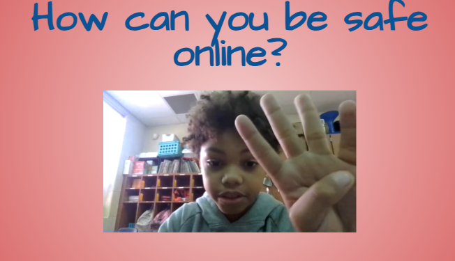 A screenshot of a student recording their Internet Safety PSA. The slide background is pink with the words “How can you be safe online?” at the top. The student raises four fingers while speaking into the camera.