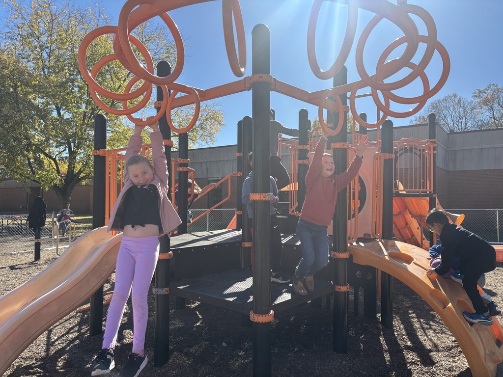 two students playing on a climbing structure