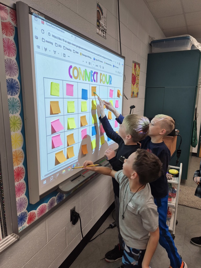 Students playing connect 4 on the smartboard