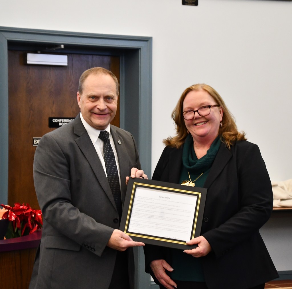 superintendent holding certificate with board member in board room