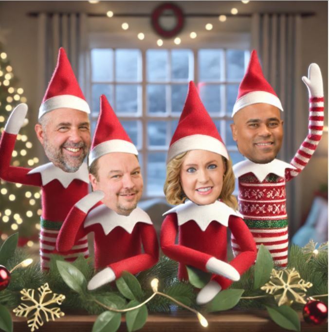 Four cheerful elf characters wearing red holiday outfits and striped stockings stand together on a festive mantel decorated with greenery, lights, and ornaments. Each elf has a smiling adult face, creating a playful holiday scene inside a decorated room.